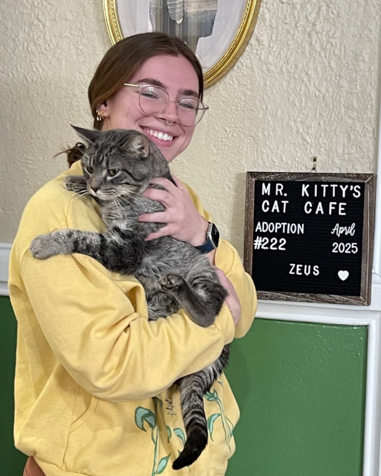 teen girl smiling while holding striped cat